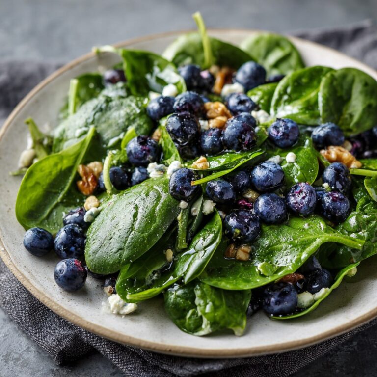 Healthy spinach blueberry salad with lemon dressing and almonds