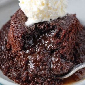 Crockpot lava cake served warm with a molten chocolate center, vanilla ice cream scoop, and powdered sugar dusting