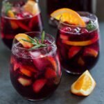 Enormous party-size Costco sangria pitcher overflowing with colorful fruit and deep red wine