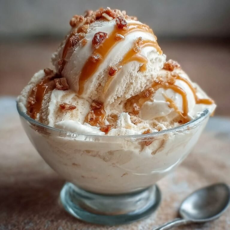 Bowl of high-protein salted caramel cottage cheese ice cream with caramel sauce drizzle, flaky sea salt, and chocolate chips on top