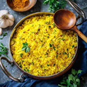 Golden garlic turmeric rice recipe in a Dutch oven with bay leaf